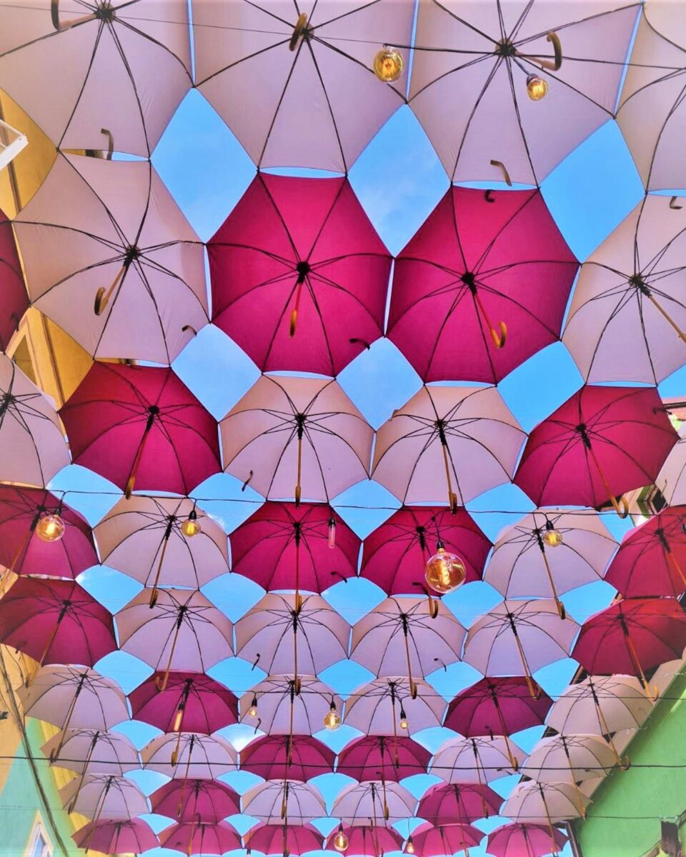 Acoperiș de umbrele colorate deasupra unei străzi din Sighișoara